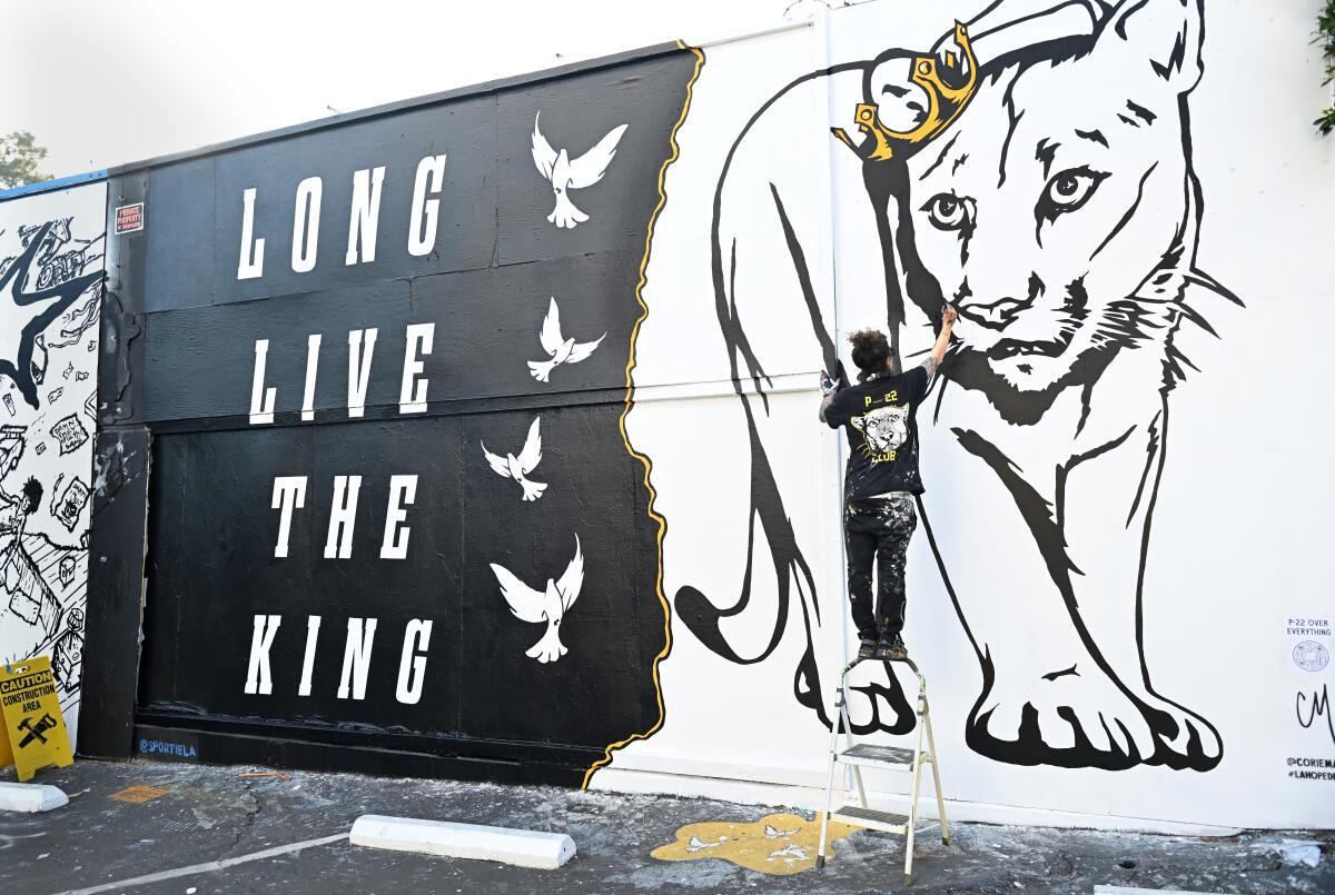 Artist Corrie Mattie paints a mural in honor of P-22 along Melrose Avenue in Los Angeles.