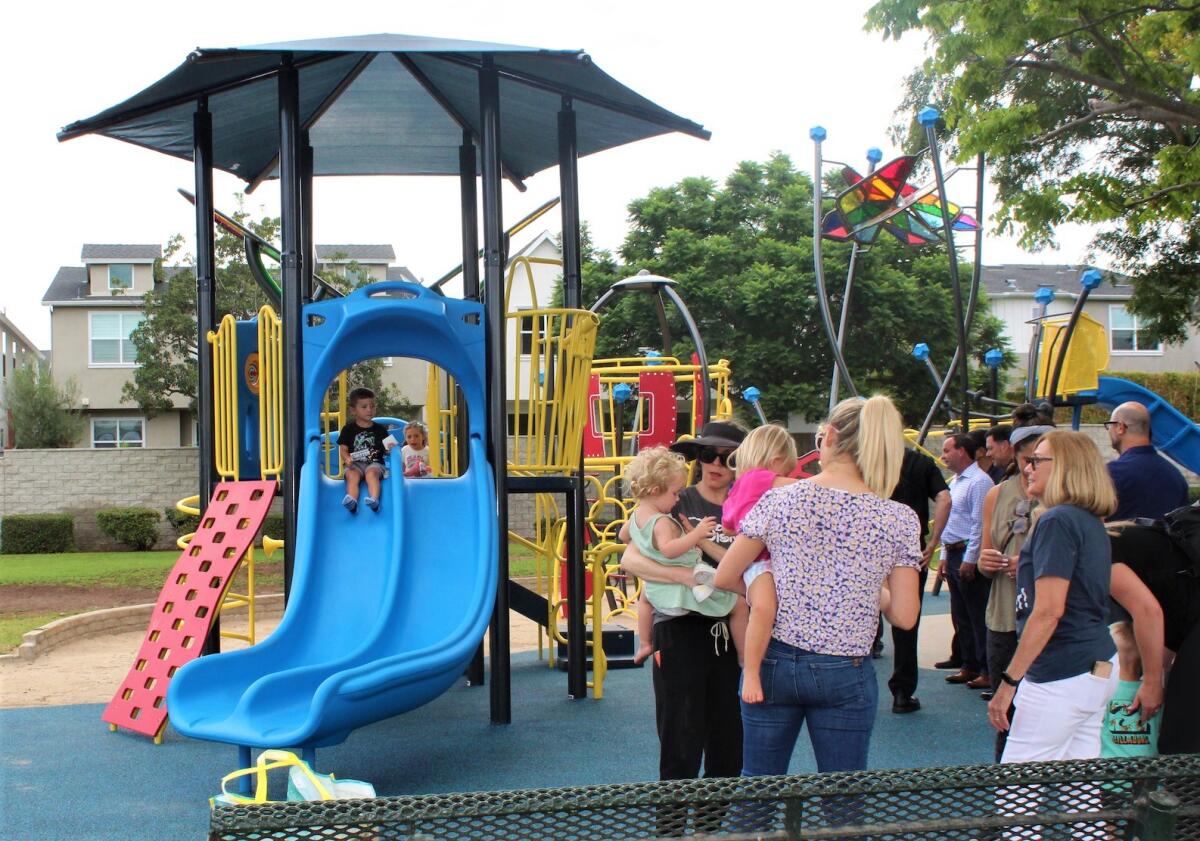 Children and parents Monday enjoy a newly installed playground at Costa Mesa's Jordan Park.