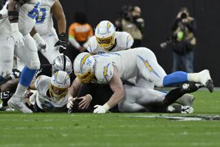 Raiders defensive end Tyree Wilson recovers a fumble by Chargers quarterback Easton Stick (2).