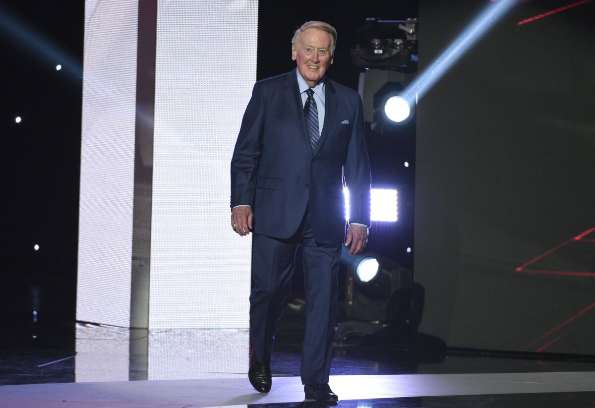 FILE - Vin Scully walks on stage to accept the Icon Award at the ESPYS at the Microsoft Theater on Wednesday, July 12, 2017, in Los Angeles. Vin Scully has won the second Lifetime Achievement Award presented by Baseball Digest. The longtime Dodgers announcer was honored Tuesday, April 12, 2022, with an annual distinction that recognizes a living individual “who has made significant contributions to the national game. ”(Photo by Chris Pizzello/Invision/AP, File)
