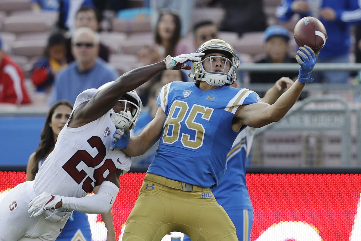 UCLA's Greg Dulcich attempts to make a one-handed catch as Stanford cornerback Kendall Williamson defends.