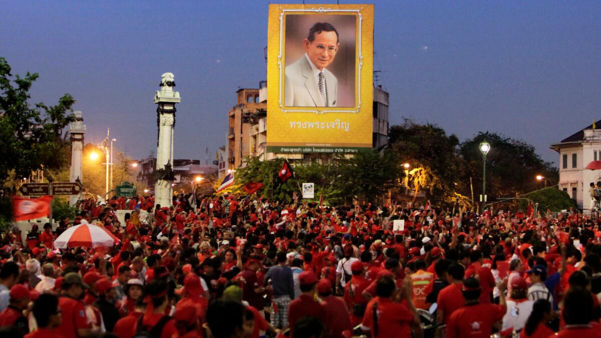 Supporters of ousted Prime Minister Thaksin Shinawatra gather under a giant portrait of King Bhumibol Adulyadej in 2005.