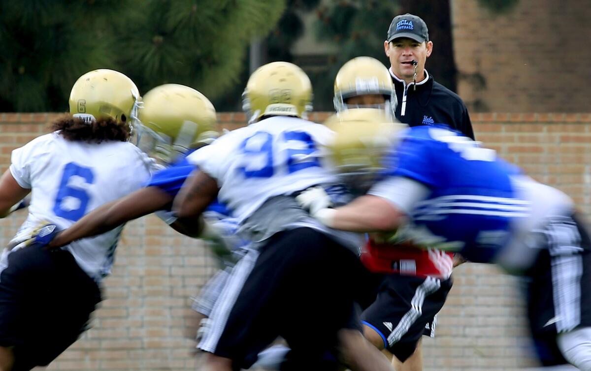 UCLA coach Jim Mora watches over his players during a spring practice session in April.