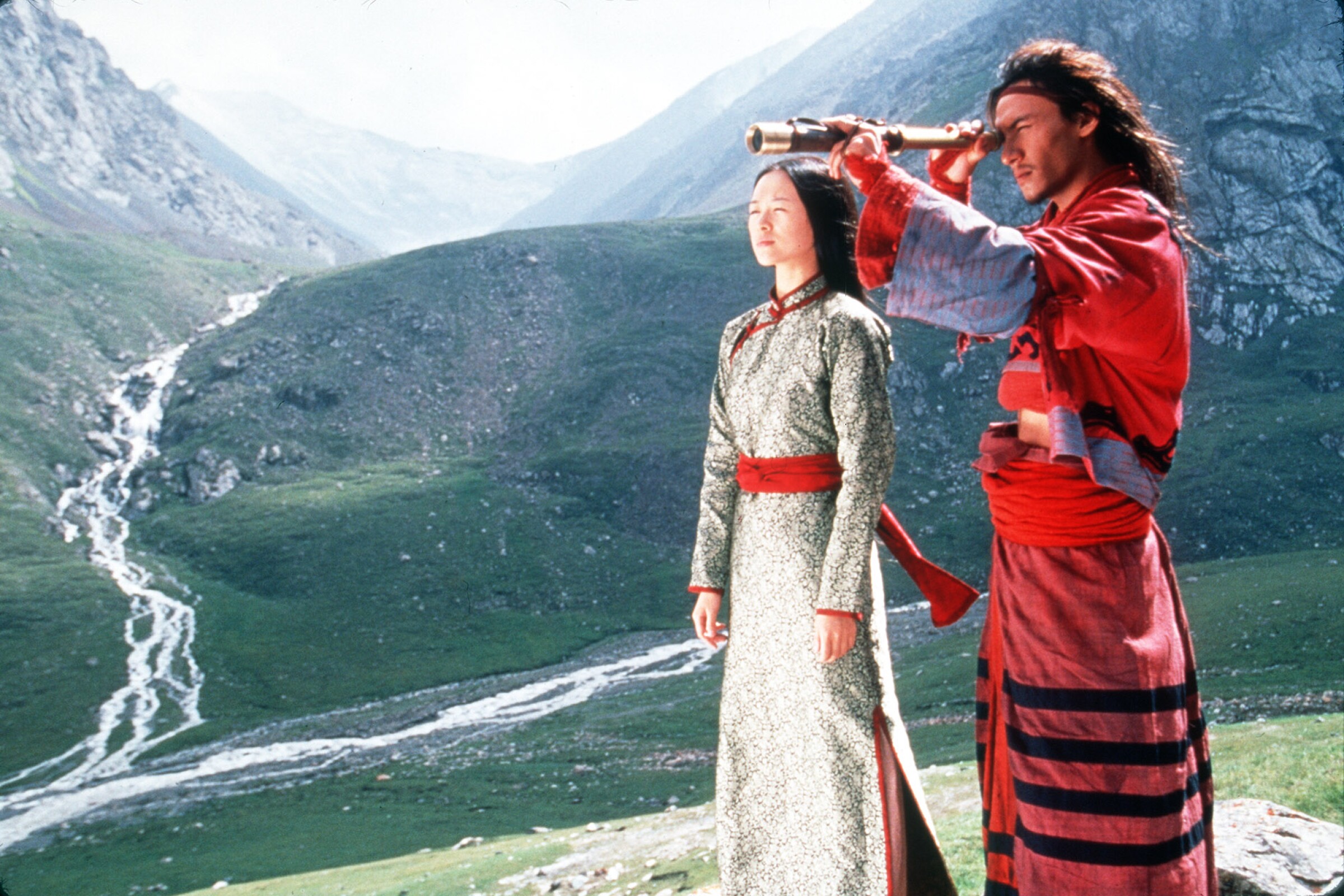 Zhang Ziyi and Chang Chen, in traditional dress, stand on a mountainside.