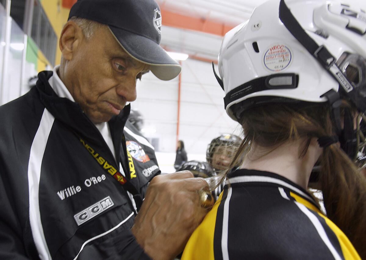 Willie O'Ree autographs a player's hockey jersey during a clinic at the Oakland Ice Centerworks in 2008.