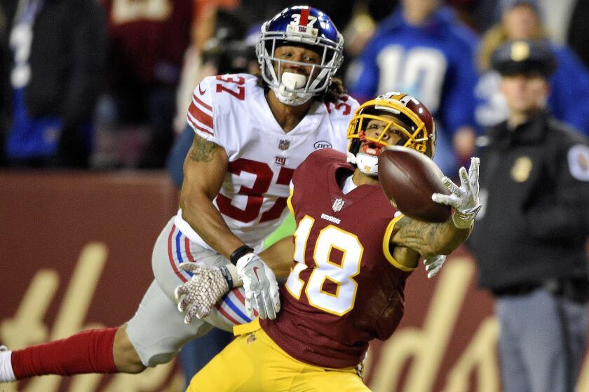 Washington Redskins wide receiver Josh Doctson (18) reaches for the ball under pressure form New York Giants defensive back Ross Cockrell (37) during the first half of an NFL football game in Landover, Md., Thursday, Nov. 23, 2017. (AP Photo/Nick Wass)