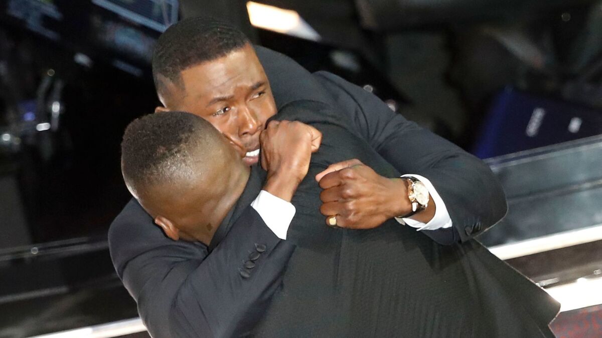 Trevante Rhodes hugs Mahershala Ali after "Moonlight" was correctly identified as the Oscar winner for best picture.
