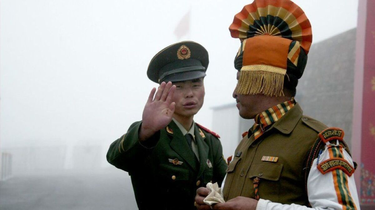A 2008 photo shows a Chinese soldier gesturing next to an Indian soldier at a border crossing.