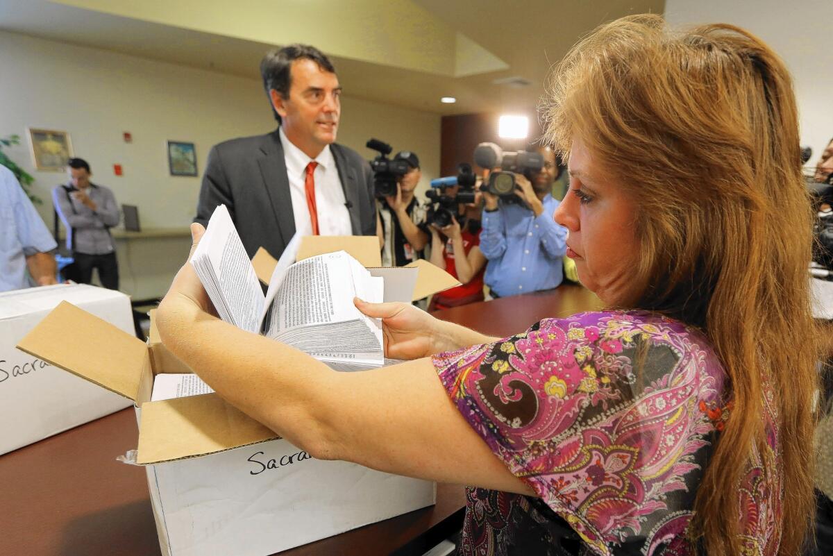 Sacramento County elections official Heather Ditty collects petitions turned in by Silicon Valley venture capitalist Tim Draper, who is backing a plan to split California into six states.