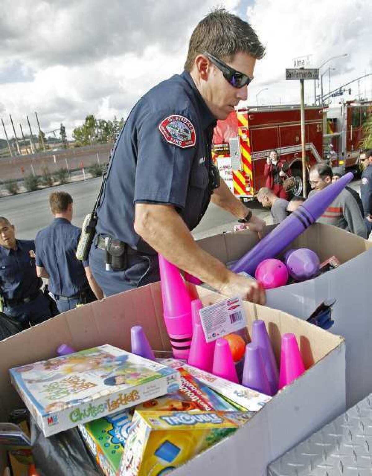 Glendale Fire paramedic Tom Nicola loads toys onto a fire department pickup in Glendale at 4 Over, Inc. Employees at 4Over, Inc. collected $5,000 in donations to purchase new toys to the 20th Annual ABC7 Spark of Love toy drive with the Glendale Fire Department.