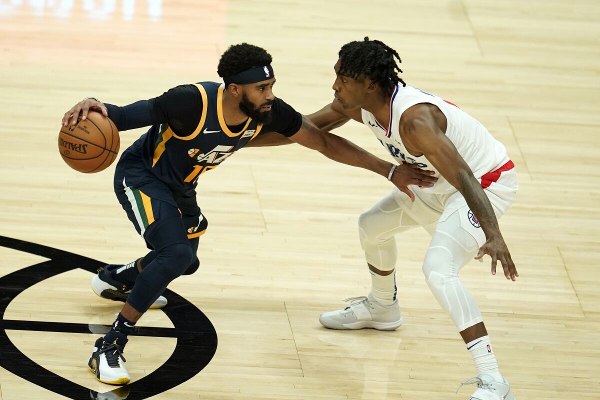 Utah Jazz guard Mike Conley tries to drive past Clippers guard Terance Mann.