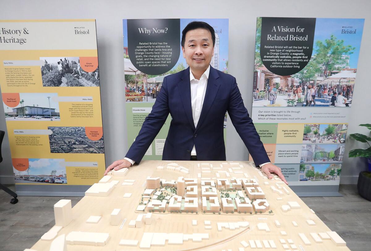 Steven Oh stands with an architectural rendering of Related Bristol in Santa Ana.