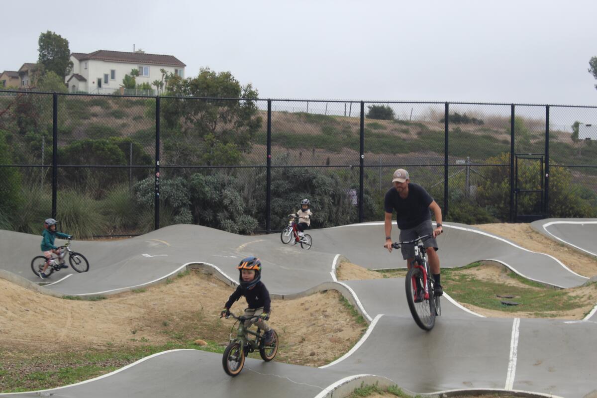 Riders of ages enjoy the pump track.