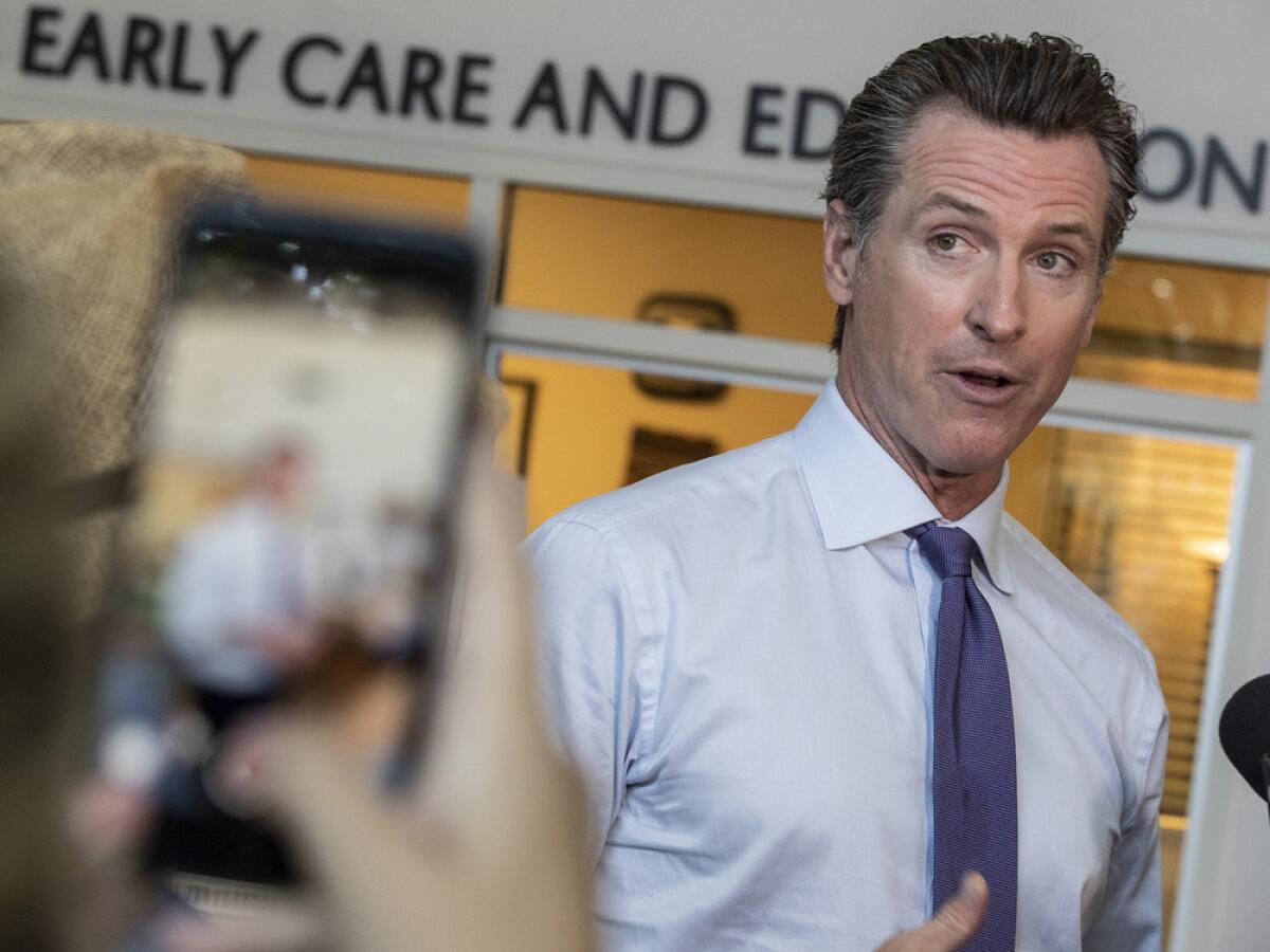 A staff member records a cellphone video of Gov. Gavin Newsom