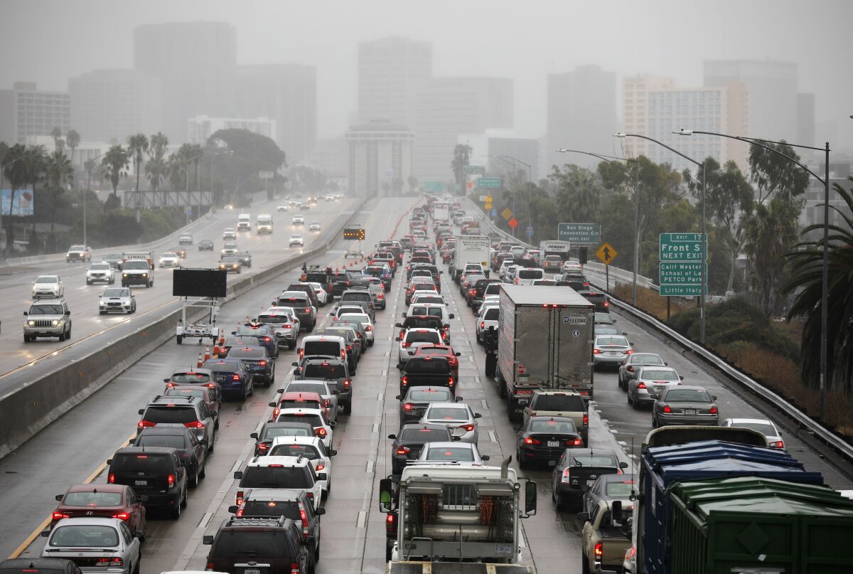 Fog envelopes buildings in downtown San Diego as traffic backed up on southbound Interstate 5