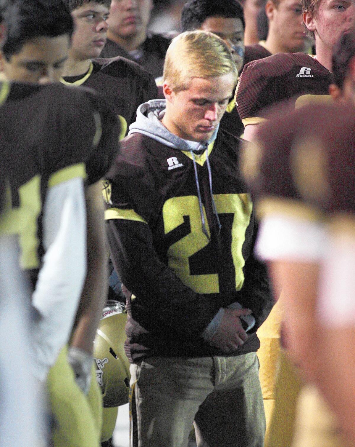 St. Francis' running back Will Huston bows his head during a pregame prayer at the playoff game against La Serna at St. Francis High School. Huston has stopped playing due to cystic fibrosis.