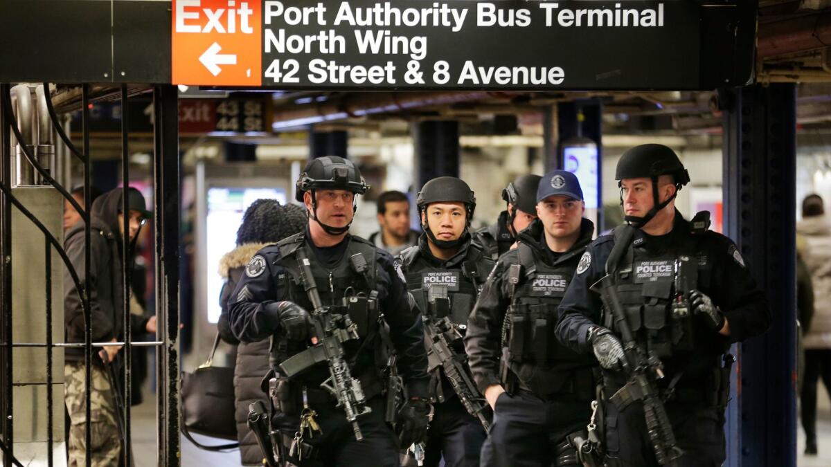 Heavily armed police patrol the passageway connecting New York City's Port Authority bus terminal and Times Square subway station on Dec. 12, near the site of the explosion the day before.