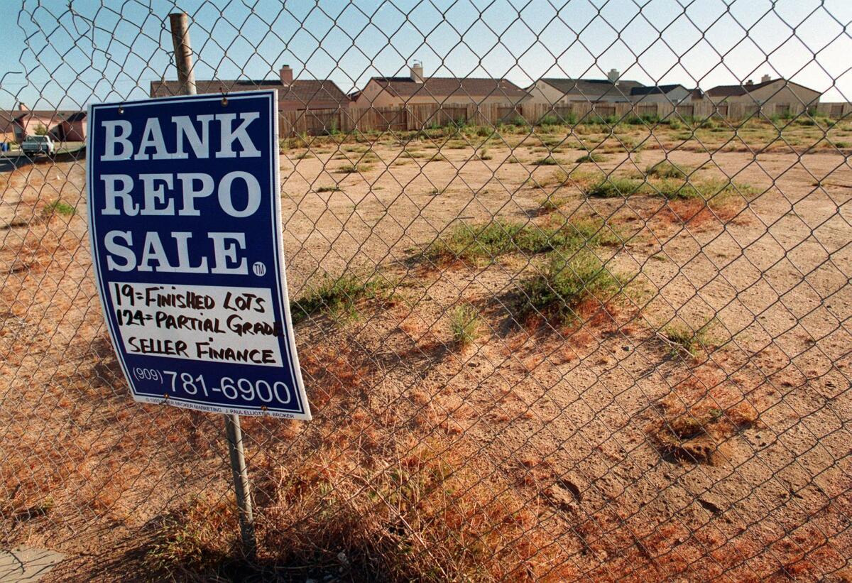 A bank repossession sign stands in front of an unoccupied housing division in April 1998, in Adelanto. The city is currently $2.6 million in debt.