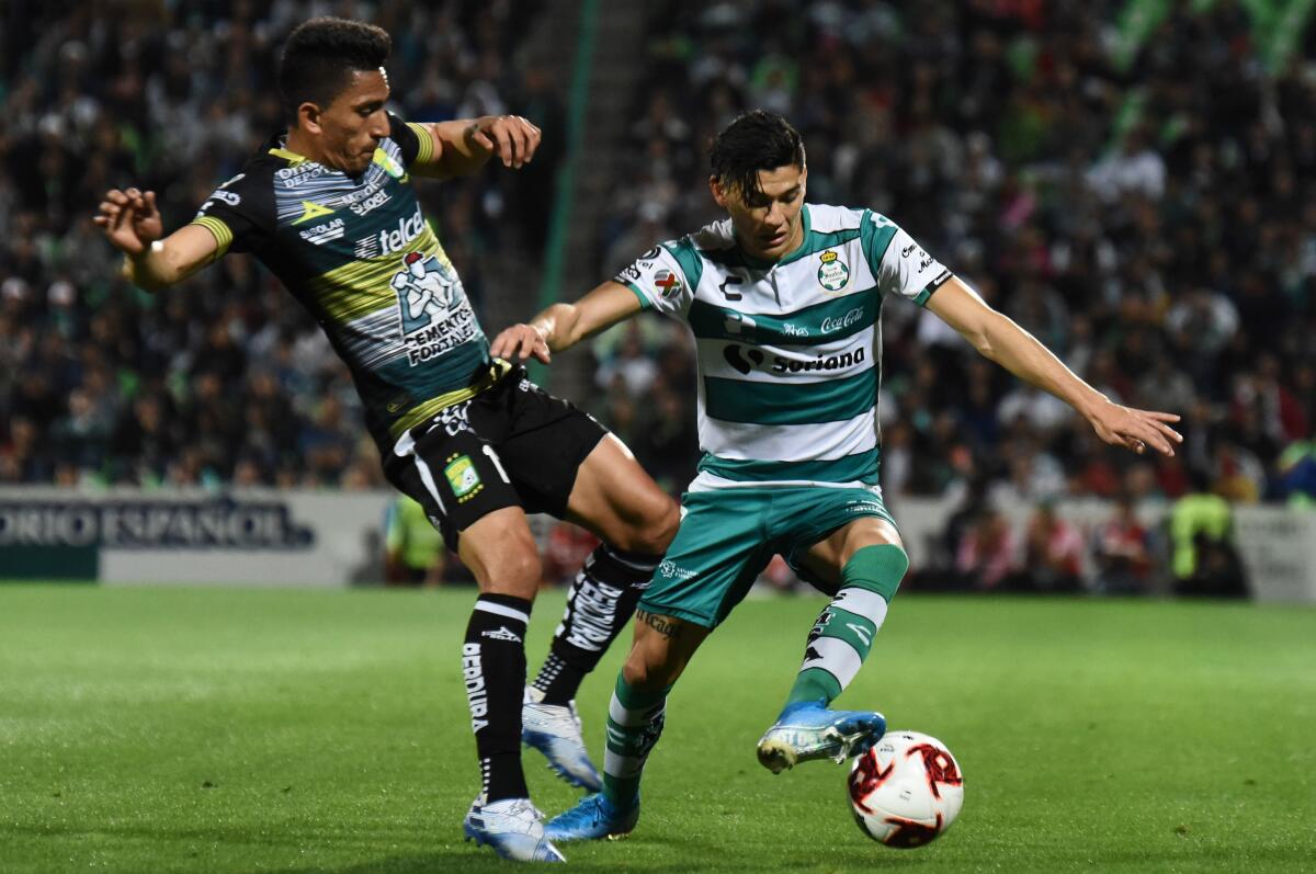 Gerardo Arteaga (R) of Santos vies for the ball with Angel Mena (L) of Leon during their Mexican Clausura 2020 tournament football match in Torreon, Coahuila state, Mexico on January 19, 2020. (Photo by ANDRES GALINDO / AFP) (Photo by ANDRES GALINDO/AFP via Getty Images) ** OUTS - ELSENT, FPG, CM - OUTS * NM, PH, VA if sourced by CT, LA or MoD **