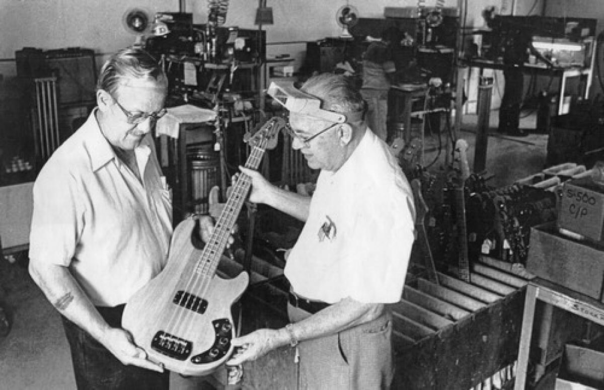 George Fullerton, left, and Leo Fender examine a guitar at their Fullerton manufacturing plant.