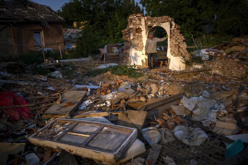 Vladimir, 66, stands next to the wreckage of his house after being bombed by Russians in Chernihiv, Ukraine, Monday, Aug. 29, 2022. On May 3, witnesses heard a plane approaching and dropping bombs that destroyed a large number of houses, including his own, killing five of his relatives who were sleeping at the time. (AP Photo/Emilio Morenatti)