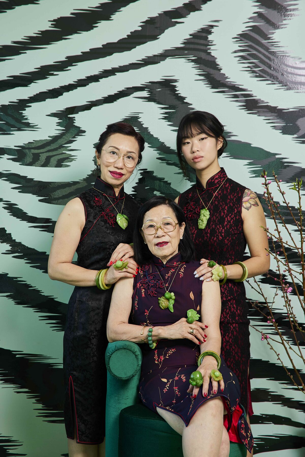 Three women wearing candy jade jewelry pose together in front of a zebra-print background.