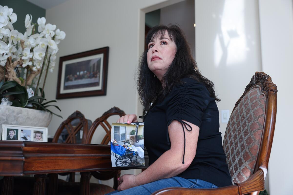 La Habra, CA - September 12: Angela Contreras poses for a portrait at home holding a picture of her late brother who suffered for four years after a doctor left gauze in his abdomen following surgery at home on Tuesday, Sept. 12, 2023 in La Habra, CA. Lawmakers are considering passing sweeping reforms of the Medical Board of California. SB 815, which lawmakers are scheduled to vote on next week, would require the board to interview the family, allow victim impact statements, raise fees to pay for enforcement, lower the standard for disciplining doctors and other changes. (Dania Maxwell / Los Angeles Times)