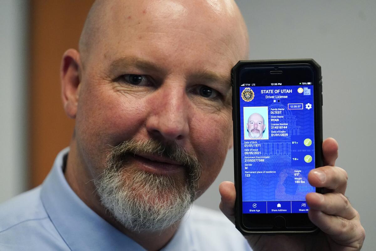 Ryan Williams holds up his cellphone with an ID on the screen.