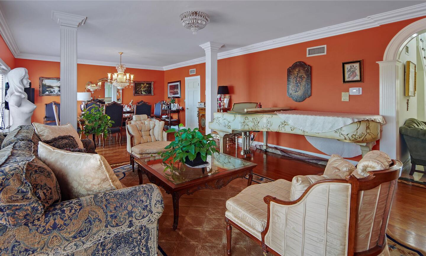 The living room is furnished and has orange walls and a white ceiling.