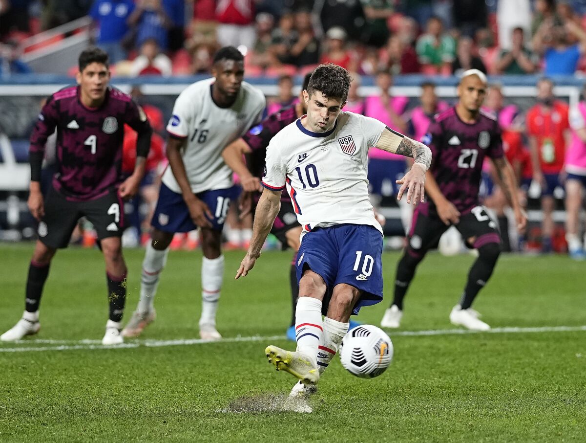 United States' Christian Pulisic kicks a penalty kick for a goal against Mexico.