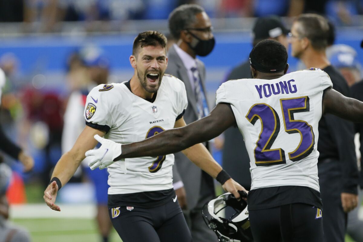 Baltimore Ravens kicker Justin Tucker (9) celebrates with Tavon Young (25) after kicking a 66-yard field goal in the second half of an NFL football game against the Detroit Lions in Detroit, Sunday, Sept. 26, 2021. Baltimore won 19-17. (AP Photo/Duane Burleson)