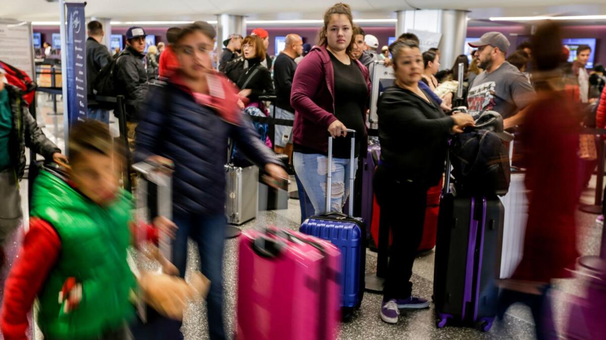Travelers tote their luggage through Los Angeles International Airport.