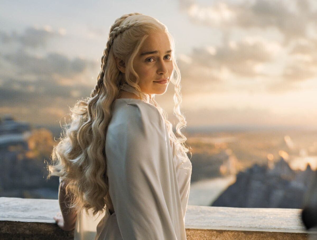 Emilia Clarke's Daenerys Targaryen standing in front of a sea view