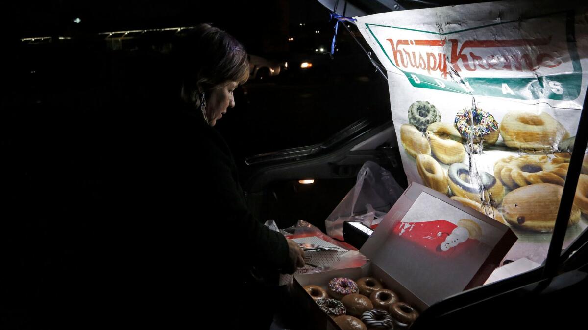 Sonia Garcia sells Krispy Kreme doughnuts, purchased across the border in El Paso, from the trunk of her car on a busy street in Ciudad Juarez, Mexico. The money she and her family make selling doughnuts helps pay for her son to go to college.