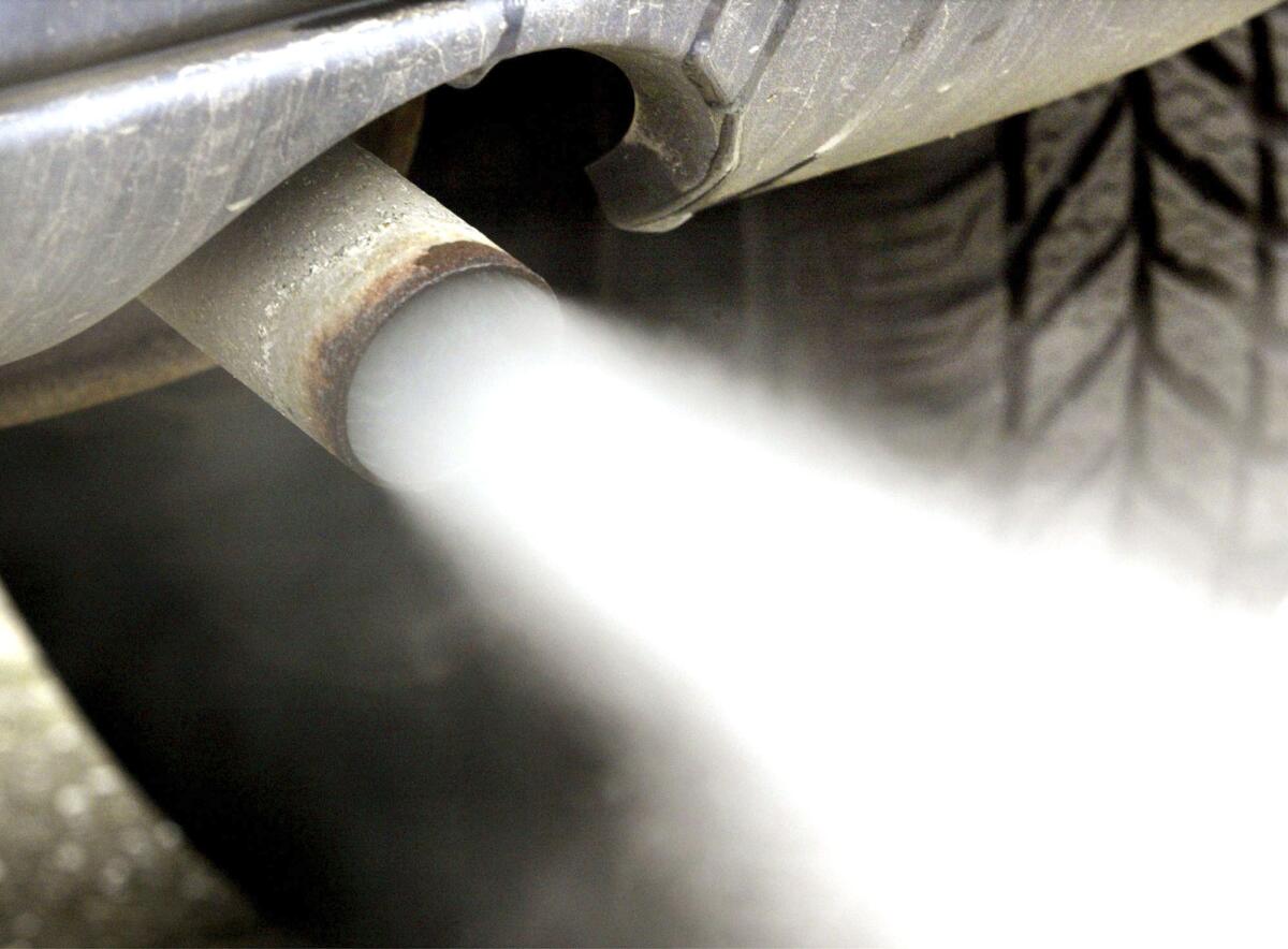 Gases leave the exhaust pipe of a car. 