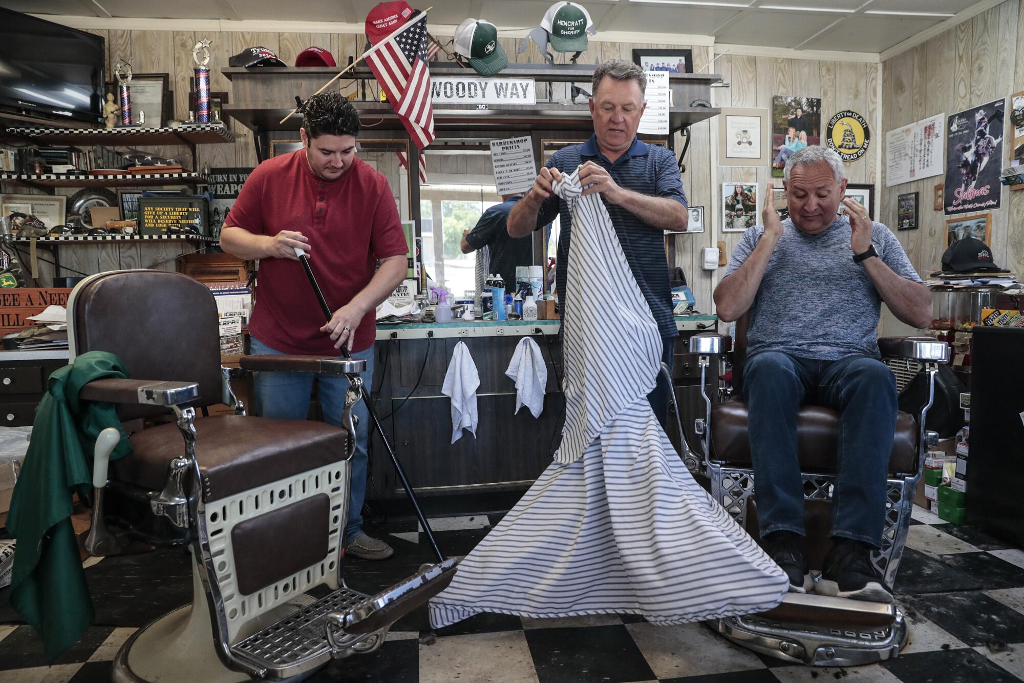 Barber Woody Clendenen, center, refused to close his business as COVID-19 spread throughout the state. 