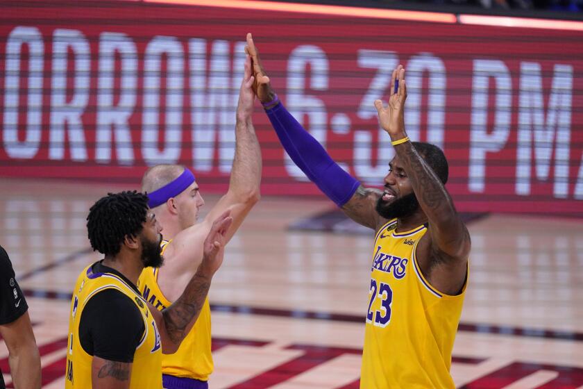 Los Angeles Lakers' LeBron James (23) celebrates with Anthony Davis, left, and Alex Caruso after an NBA conference semifinal playoff basketball game against the Houston Rockets Thursday, Sept. 10, 2020, in Lake Buena Vista, Fla. The Lakers won 110-100. (AP Photo/Mark J. Terrill)
