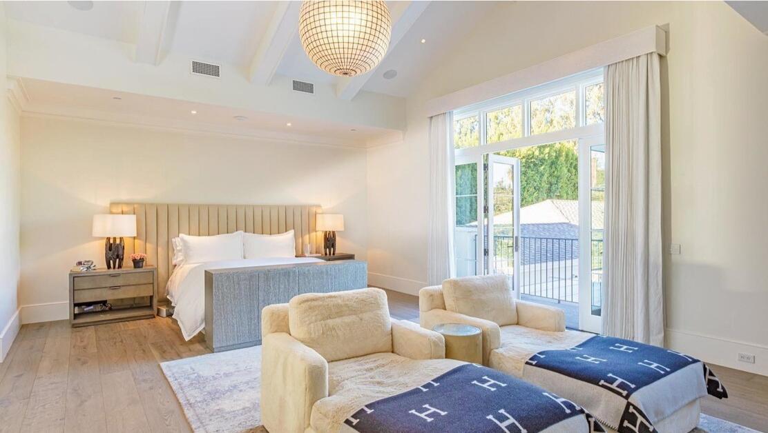 The furnished primary bedroom with a window overlooking the yard.