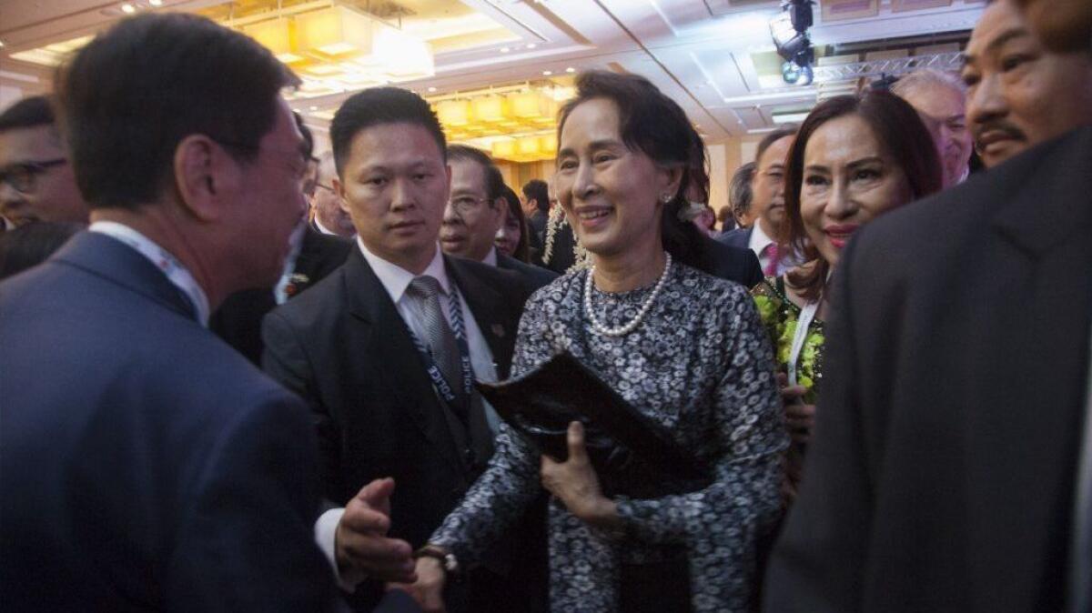 Aung San Suu Kyi meets an audience member after delivering a speech Sunday in Singapore.