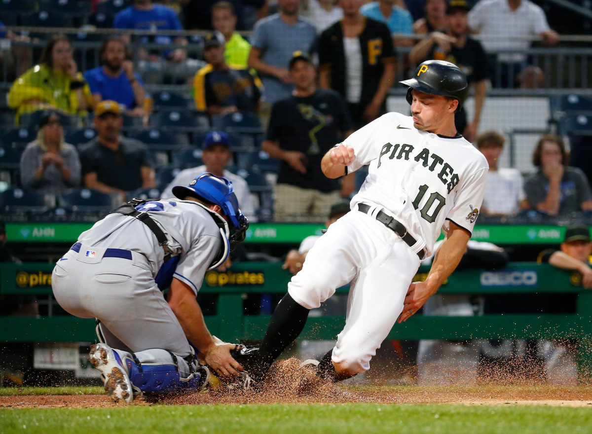 Pirates baserunner Bryan Reynolds beats the tag from Dodgers catcher Will Smith to score during the first inning.