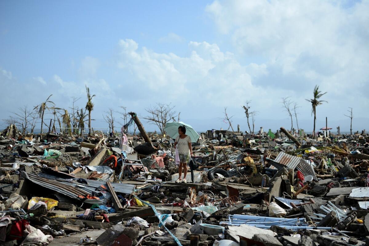 A survivor walks among the debris of houses destroyed by Typhoon Haiyan.