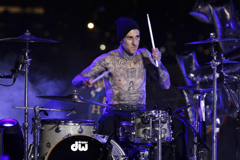 Musician Travis Barker plays drums at the Tommy Hilfiger Fall 2022 collection is modeled during Fashion Week, Sunday, Sept. 11, 2022, in New York. (AP Photo/Jason DeCrow)