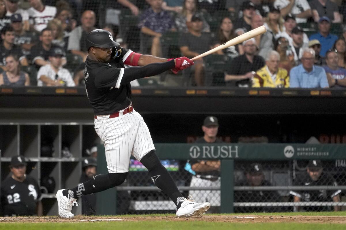Chicago White Sox's Eloy Jimenez swings through a two-run double off Kansas City Royals starting pitcher Brad Keller, during the fourth inning of a baseball game Tuesday, Aug. 2, 2022, in Chicago. (AP Photo/Charles Rex Arbogast)