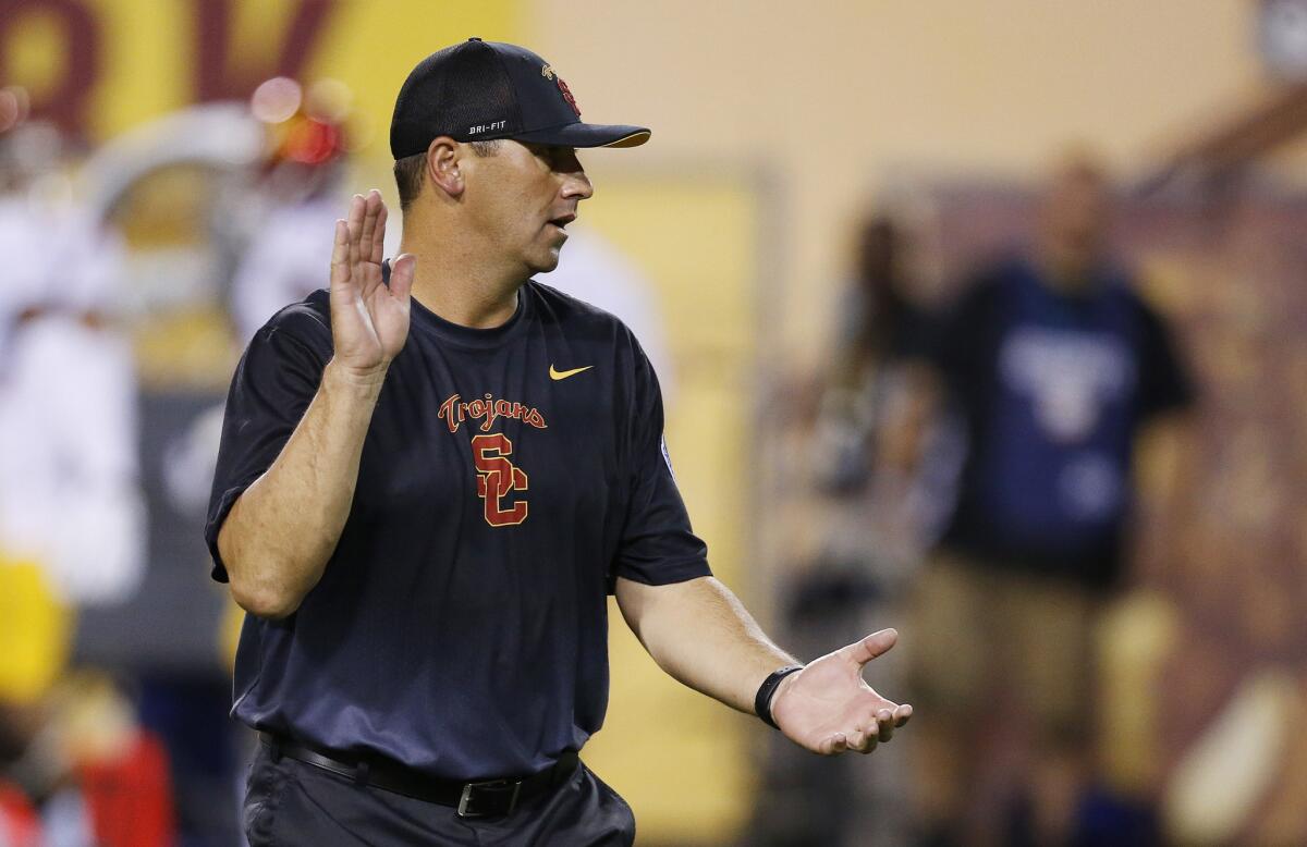 USC Coach Steve Sarkisian gets his players fired up as they warm up before a game against Arizona State on Sept. 26.