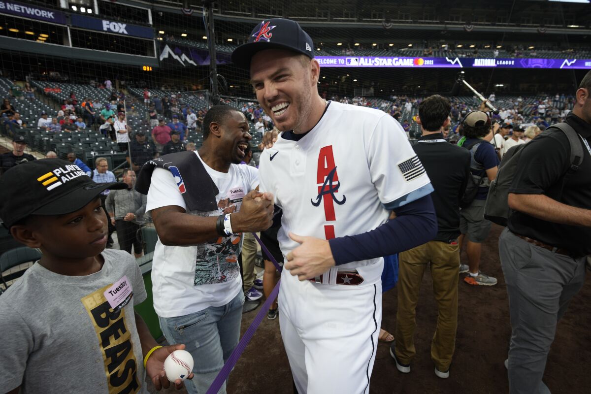 National League's Freddie Freeman, of the Atlanta Braves, laughs with former player Michael Bourn