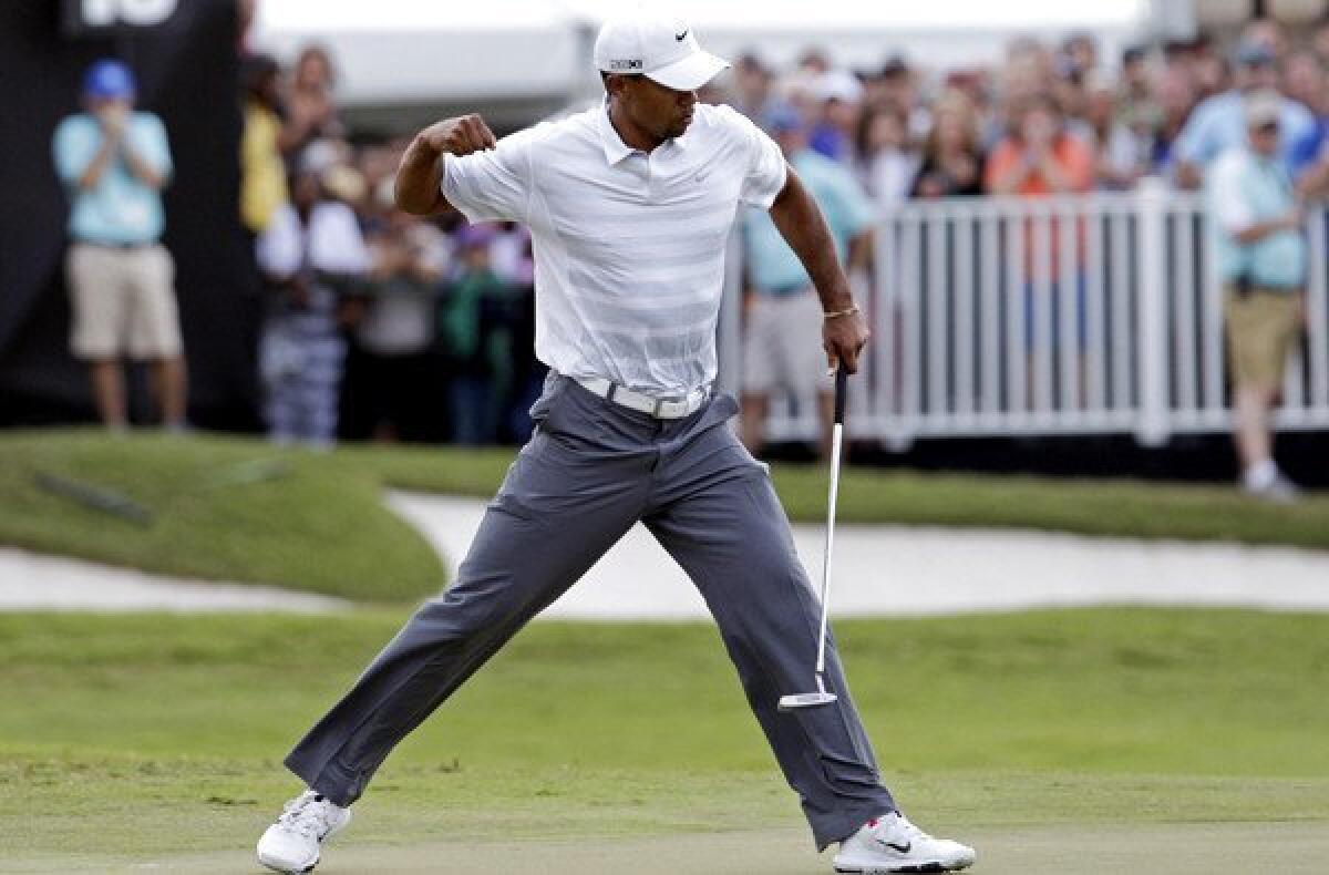Tiger Woods pumps his fist after making a birdie putt on the 18th hole Saturday during the third round of the Cadillac Championship.