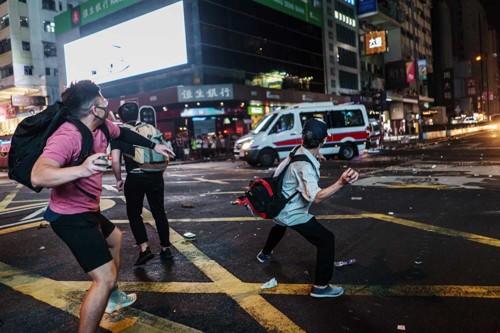 \Protester attack police vans with bricks as the vehicles pull out from the Mong Kok district of Hong Kong.