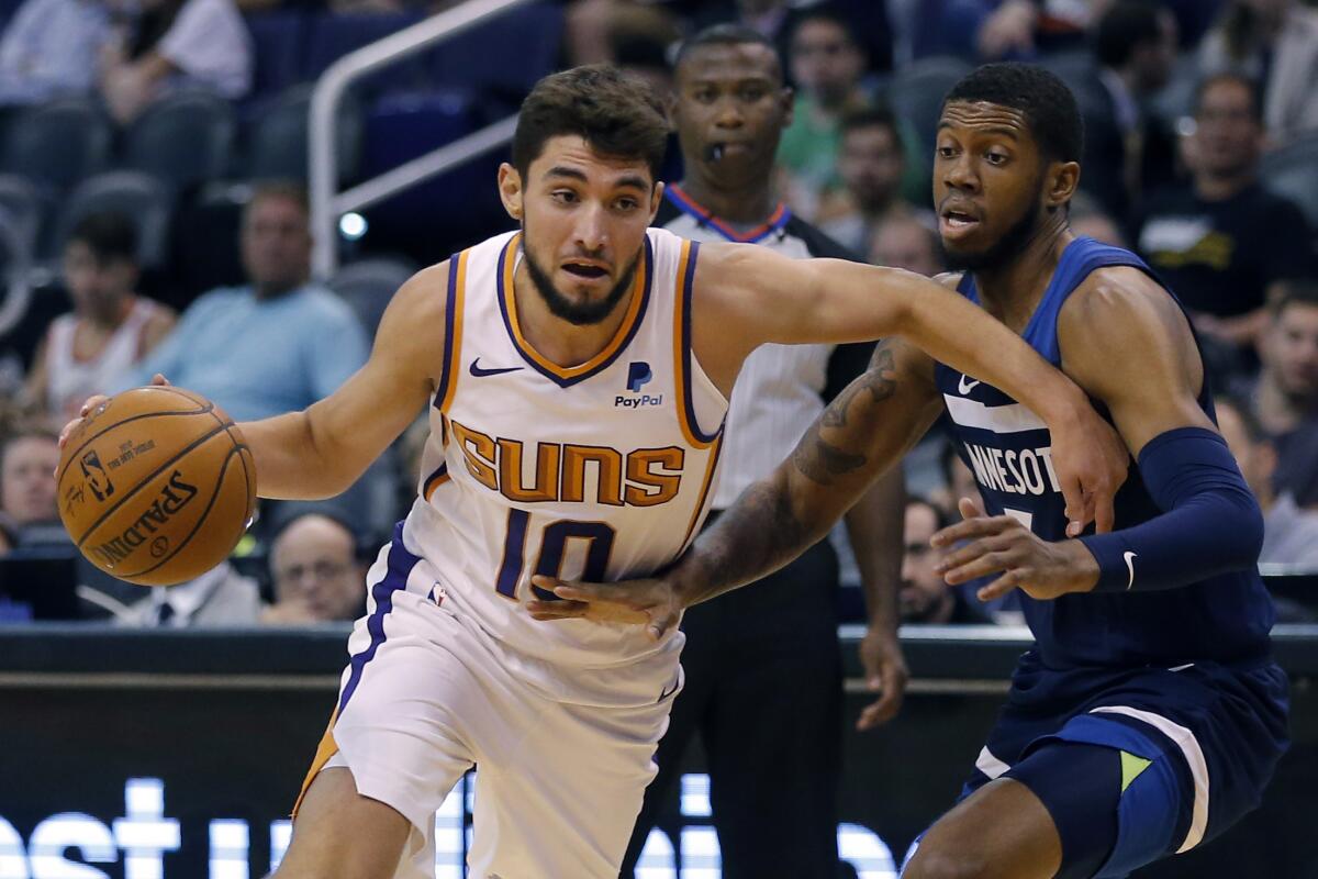 Phoenix Suns guard Ty Jerome (10) drives on Minnesota Timberwolves guard Tyrone Wallace during the second half of a preseason NBA basketball game, Tuesday, Oct. 8, 2019, in Phoenix. (AP Photo/Rick Scuteri)