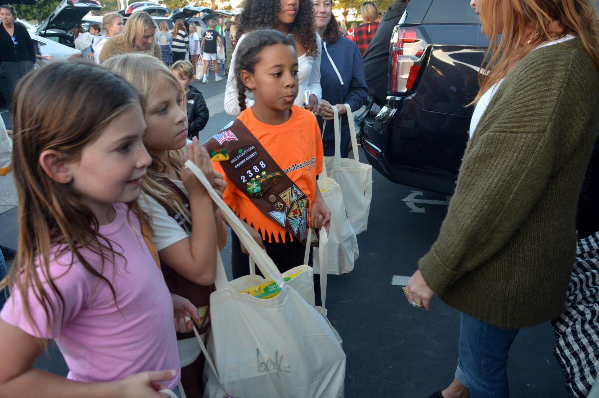 A Brownie troop lines up to fill bags during the Trunk & Pack food drive at St. Andrews Presbyterian Church.
