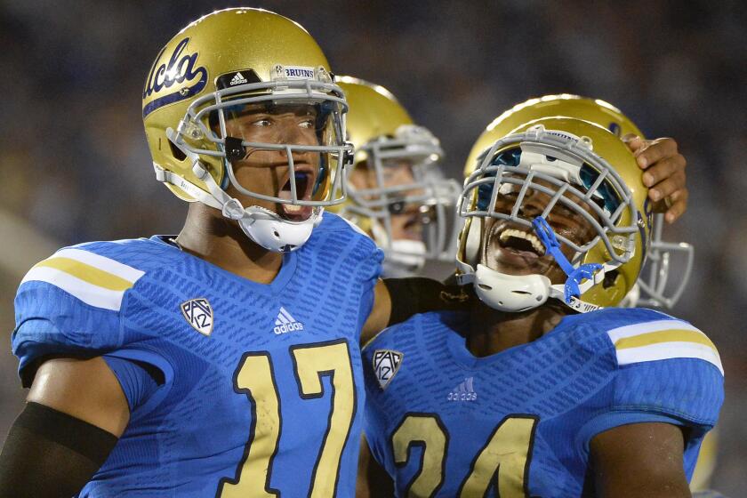 UCLA quarterback Brett Hundley, left, and running back Paul Perkins celebrate a touchdown against Nevada last season. Count Virginia Coach Mike London among the Hundley admirers.